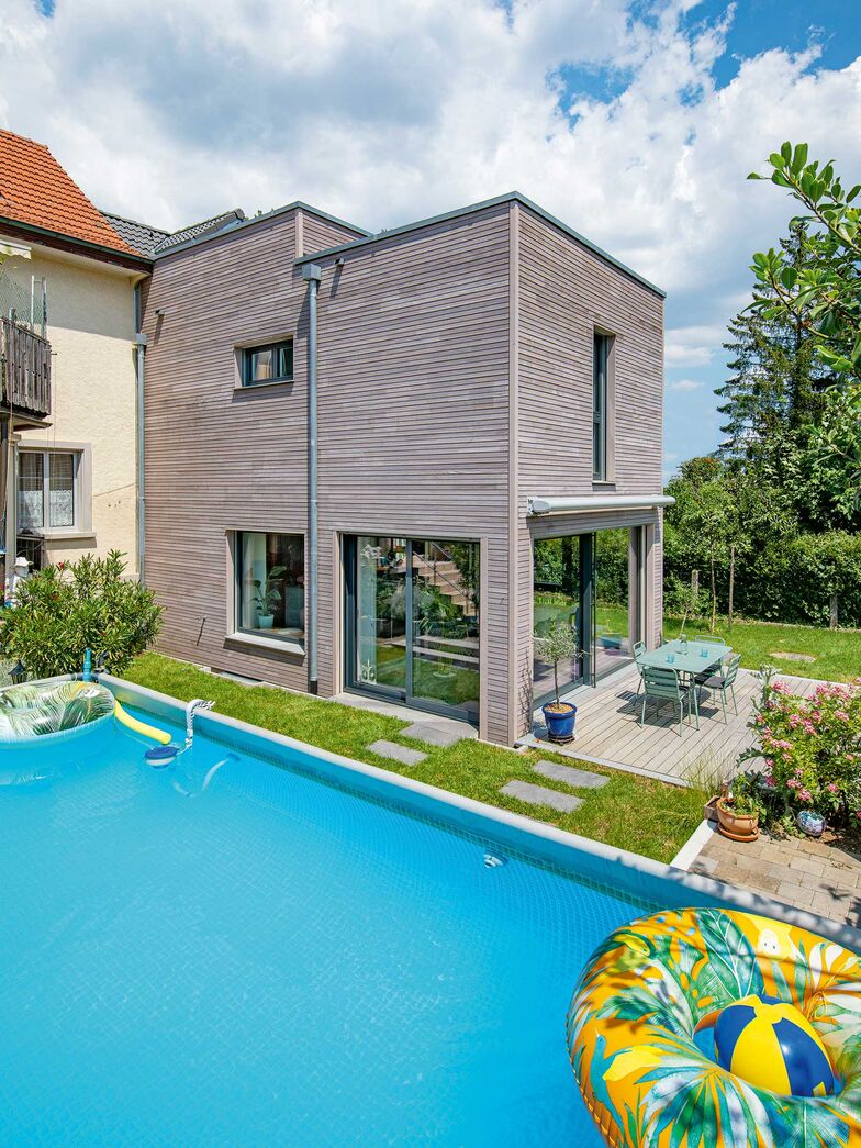 Der Winkel zwischen Alt- und Neubau bildet einen geschützten Bereich und ist ein idealer Platz für den Pool der Grossfamilie.