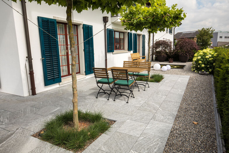 Die Gartenprofis haben auch den Sitzplatz neu gestaltet. Dichte Baumkronen zweier Schirmplatanen spenden hier Schatten.