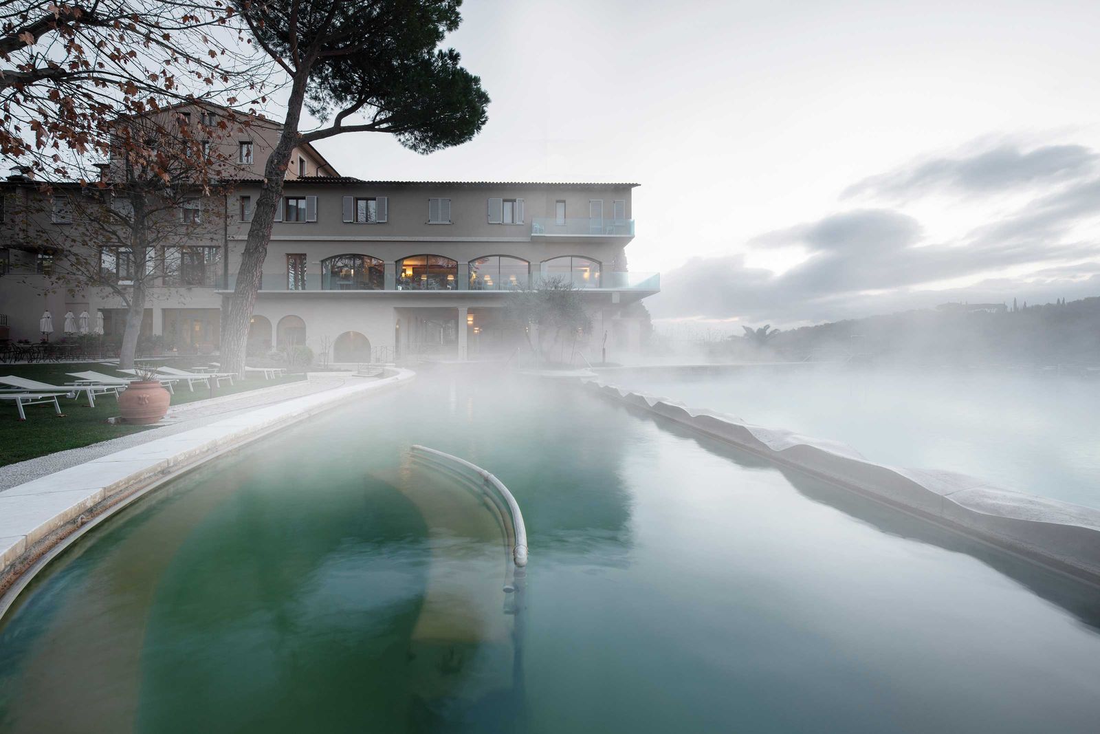 An das Thermalschwimmbecken schliesst ein grosser Garten mit vielen Sitzgelegenheiten.