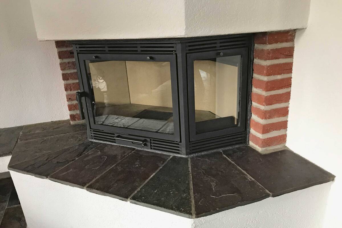 So schnell kann man die Wärme des knisternden Feuers geniessen: Der massgefertigte Heizeinsatz wird ohne Umbau in die bestehende Cheminéeöffnung eingeschoben. Novatherm Öfen AG.