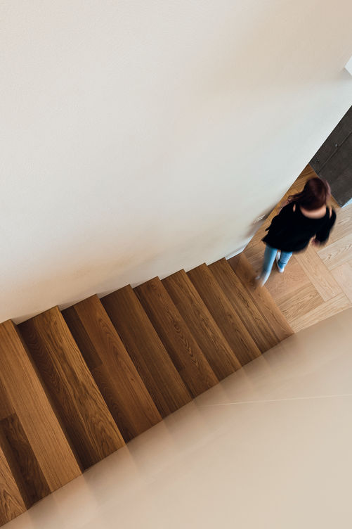 Boden und Treppe in Eiche – kommen sie aus derselben Fertigung, haben beide trotz unterschiedlichem Charakter die gleiche Farbe und Oberflächenbehandlung sowie den gleichen Glanzgrad. Bauwerk Parkett.